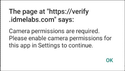 Android WebView alert shown by ID.me when camera permission is unavailable. The alert says camera permissions are required and asks the user to enable camera permissions for the app in Settings.