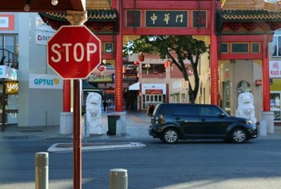A street scene featuring a red octagonal stop sign mounted on a brown pole on the left side of the image.